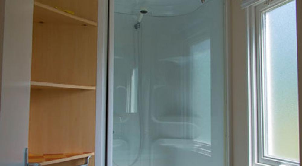 Cuarto de aseo espacioso con cabina de ducha y lavabo